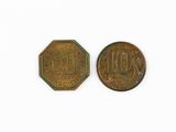 two old coins are sitting side by side on a white surface