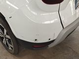 the rear end of a white car with a broken bumper