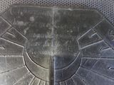 a close up of a metal plate with a clock on it