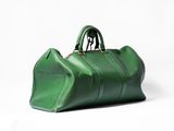 un sac à main vert posé sur une surface blanche
