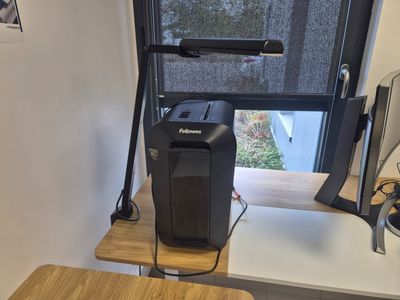 a computer on a desk in front of a window