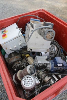 a red box filled with assorted electronics on the ground