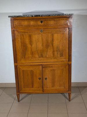 a wooden cabinet with a marble top in the corner of a room