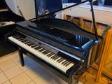 a piano in a room with a piano stand in the corner