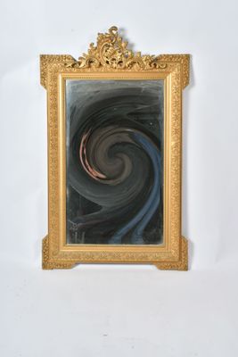 une photo d'un miroir à cadre doré présentant un motif en spirale