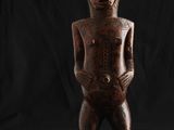 une statue en bois représentant un homme debout sur un skateboard