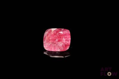 un gros plan d'une pierre rose sur une surface noire