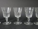 four wine glasses are lined up on a black surface
