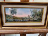 painting of a landscape with trees and a river in a gold frame