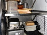 a metal shelf with pots and pans on top of it