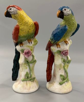 paire de perroquets en céramique colorés, perchés sur une branche ornée de roses