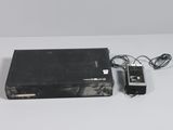 a video game console and a charger on a white surface