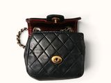 a small black purse with a chain hanging from it