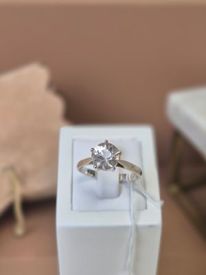 une boîte blanche contenant un anneau, posée sur une table
