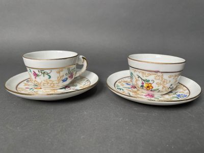 two cups and saucers with floral designs are sitting on a table