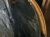un parapluie noir emballé dans du plastique, posé sur une table en bois