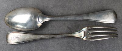 deux cuillères et une fourchette en argent sur une table