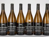 six bouteilles de vin sont alignées sur une surface blanche