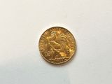 a close up of a gold coin on a white surface