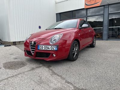 la voiture rouge est garée devant un bâtiment dans un parking