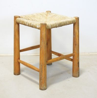 an image of a wooden stool with a woven seat on it