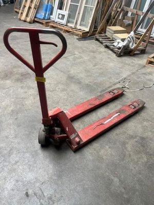 a red hand truck that is sitting in a warehouse