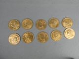 Plusieurs pièces d'or sont disposées en rangée sur une table