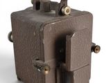 a small brown suitcase with a handle on top of it