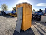 a yellow portable toilet sitting in a parking lot