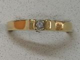 une photo d'une bague en or jaune sertie d'un diamant
