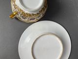 two cups and saucers are sitting on a table next to each other