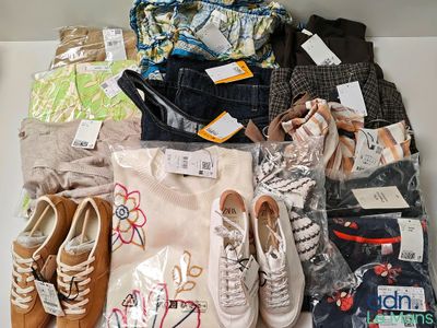 Plusieurs paires de chaussures et un sac de vêtements sont posés sur une étagère