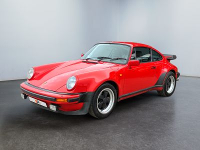 une photo d'une Porsche Turbo rouge dans un showroom