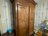 une photo d'une chambre à coucher avec une grande armoire en bois