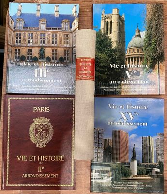Plusieurs livres sont posés sur une table devant un bâtiment.