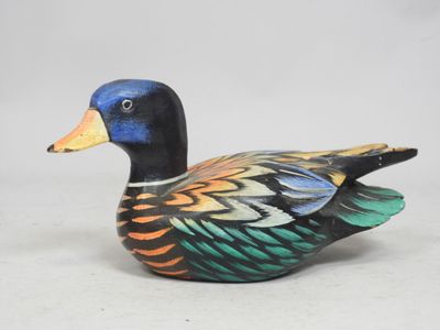 an image of a wooden duck sitting on top of a white surface