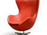 an orange leather egg chair with a metal base on a white background