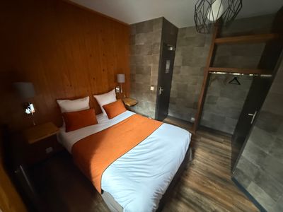 une photo d'une chambre à coucher avec un lit et une armoire
