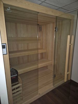 un sauna situé dans un coin de la pièce, doté d'une porte vitrée