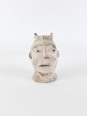 sculpture of a man ' s head on a white surface with a white background