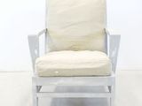 a white chair with a cushion on it in a room