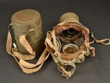 an old pair of gas masks and a canister on a table