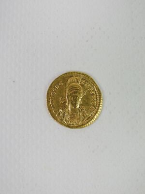 gros plan d'une pièce d'or sur une surface blanche