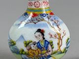 un petit vase orné d'une peinture, posé sur une table