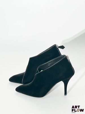 une paire de chaussures noires à talons hauts posée sur une surface blanche