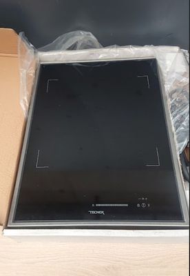 a black stove top sitting in a box on a table