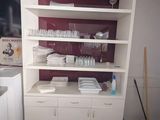 a kitchen with white cabinets and a red wall