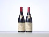 two bottles of red wine sitting on top of a table