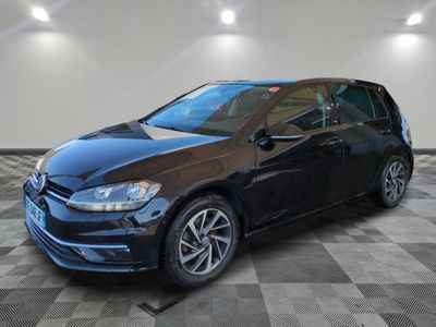 a black volkswagen golf is parked on a checkered floor