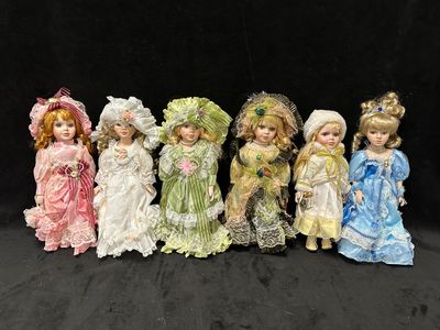 six poupées en porcelaine sont alignées en rang sur un fond noir